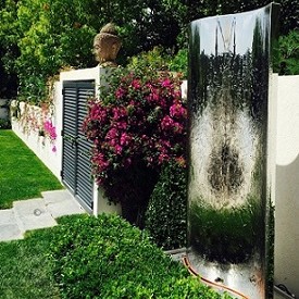 Dissimulation mur par fontaine et bougainvilliers